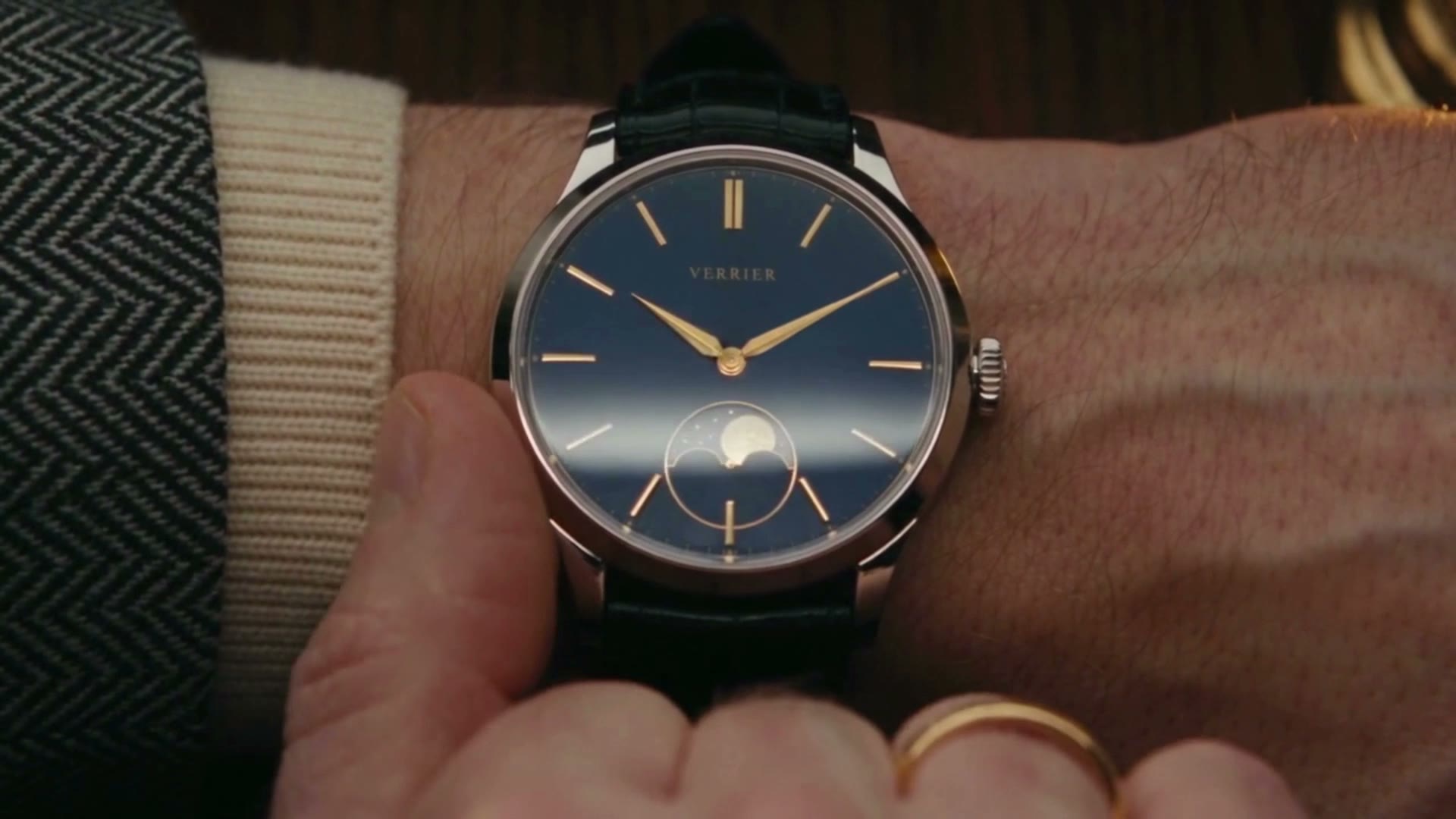 His thumb on the bezel of the moon dial